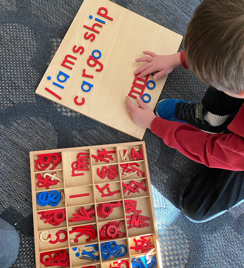 student playing with wood letters