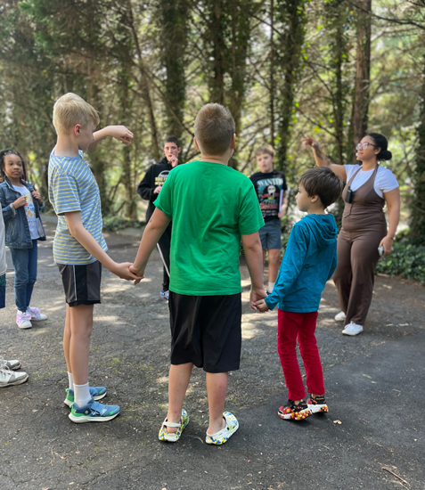 students standing in a circle and holding hands