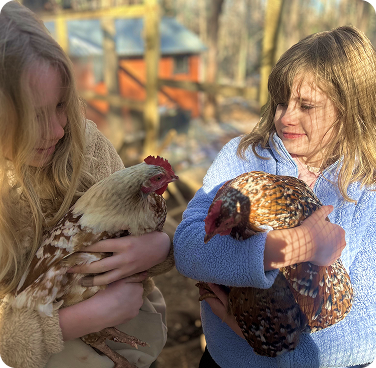 girls holding chickens