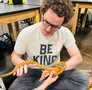 student with snake on hands