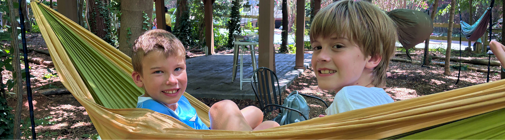 two happy campers sitting in a hammock 