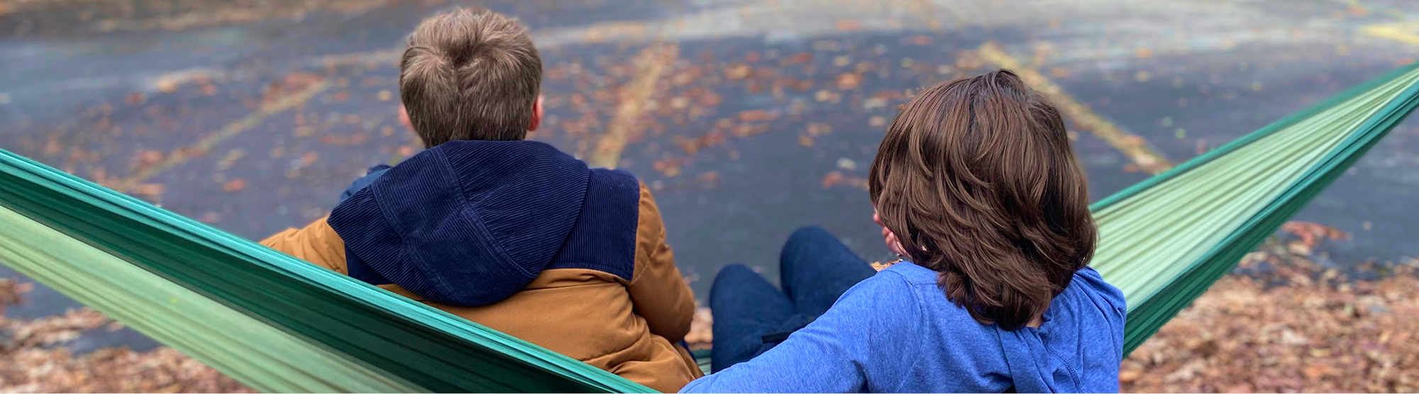 two boys sitting in a hammock 